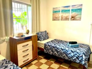 a bedroom with a bed and a desk and a window at Guest House Rosa do Mar in Olinda