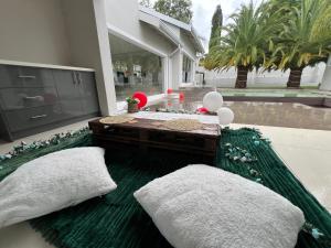 a patio with a table and a green rug at Vinorisa Spa & Lodge in Pretoria