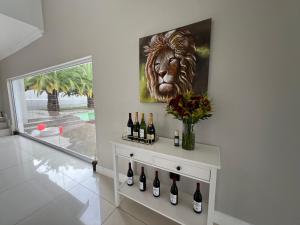a room with a lion painting on the wall and wine bottles at Vinorisa Spa & Lodge in Pretoria