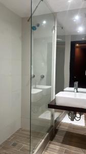 a bathroom with a sink and a glass shower at Hotel Grand Galaxie in Caracas +53 photos