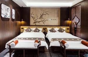 平遥Shanxi Merchant Mansion的一间有三张床的酒店房间