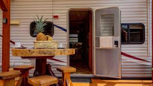 a table in front of a trailer with a table with pineapple at joy of fruits in Brisas de Zicatela