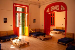 亚历山大Ithaka Raml Hostel的建筑物内有沙发和桌子的房间