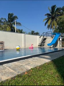 a swimming pool with a slide and a playground at Bolgoda Lake Villa in Moratuwa