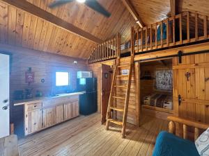 Un dormitorio con una litera y una cocina en una cabaña. en Katie's Cozy Cabins, en Tombstone