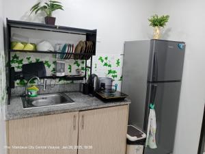 a kitchen with a sink and a refrigerator at Lloyds Barato 2BR Condo Unit 6paxMax in Mandaue City