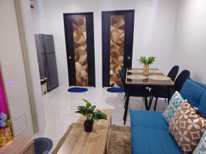 a living room with a blue couch and a table at Lloyds Barato 2BR Condo Unit 6paxMax in Mandaue City +11 photos