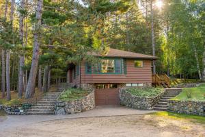 une maison avec un garage dans les bois dans l'établissement Cabin O' Pines - A Family Friendly Resort, à Orr