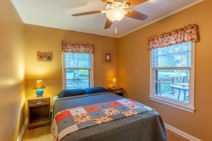 une chambre avec un lit et un ventilateur de plafond dans l'établissement Cabin O' Pines - A Family Friendly Resort, à Orr