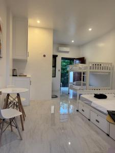 a large white kitchen with a bed and a table at CasaJuana Room Rental in Carles +44 photos