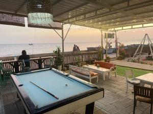 una mesa de billar en un patio junto al océano en EVA HUT Mui Ne Beach Hostel, en Mui Ne