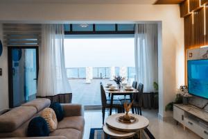 a living room with a couch and a table at Aina Residency Beachfront Hotel in Male City
