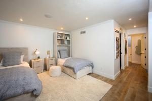 a bedroom with two beds and a book shelf at 4BR Luxury Del Mar Beach House with Ocean Views in San Diego