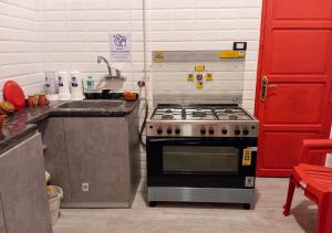 a kitchen with a stove and a sink at Ithaka Raml Hostel in Alexandria