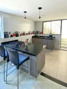 a kitchen with a counter and some chairs in it at Apartamento San Gil Amoblado in San Gil +9 photos