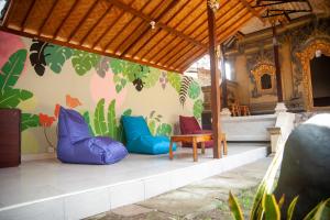 a room with colourful pillows and a chair and a wall at The Cube Hostel Penida in Sampalan