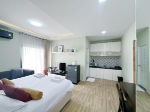 a bedroom with a large bed and a kitchen at Daddy Dream Hotel and Residence in Ranong