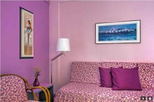 a living room with purple walls and a couch at apartment in Amoudara of Heraklion-4 in Ayía Marína