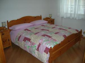 a bedroom with a bed with a quilt on it at Appartamento Zorzi in Ziano di Fiemme