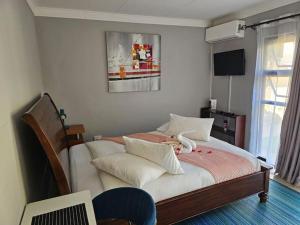 a bedroom with a large bed with white sheets at Pool house in Polokwane