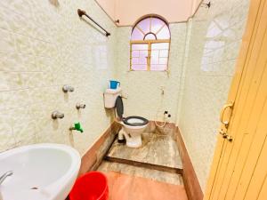 a bathroom with a toilet and a sink at Lodge Bikash in Siliguri +36 photos