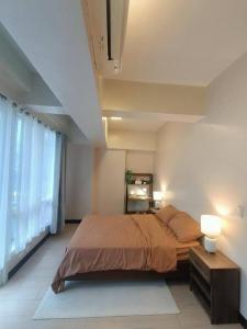 a bedroom with a large bed and a window at Mactan Newtown in Lapu Lapu City
