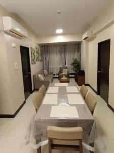 a living room with a large table and chairs at Mactan Newtown in Lapu Lapu City