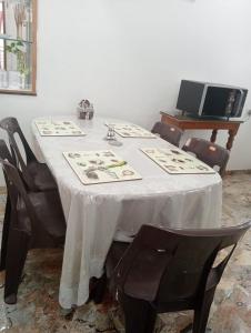 ナーシクにあるStay NC 2BHK apartmentの白いテーブルクロスと椅子付きのテーブル