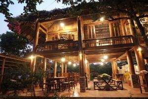 a wooden house with a table and chairs at night at MAMA's House Mộc Châu in Mộc Châu