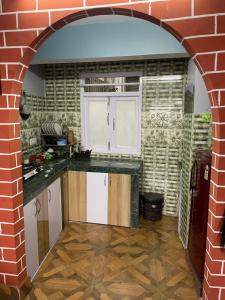 a kitchen with an archway in a brick wall at Blue Valley Apartment in Darjeeling +6 photos