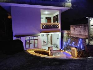 a house with blue lights on the side of it at villa beringin by andi tour in Sampal 2