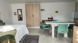 a room with a bed and a table and chairs at Foundation Stones Lodge Summerstrand in Gqeberha
