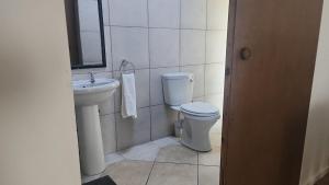 a bathroom with a toilet and a sink at Foundation Stones Lodge Summerstrand in Gqeberha +29 photos