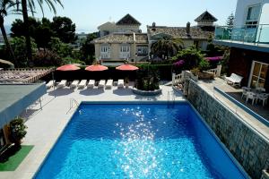 una piscina frente a una casa en Hotel Complejo Los Rosales, en Torremolinos