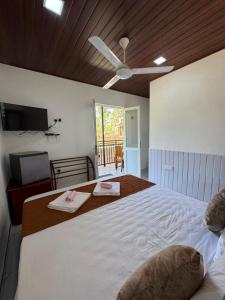 a bedroom with a large bed with a ceiling fan at Ella RV Heaven World Hotel in Ella