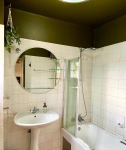 a bathroom with a sink and a shower and a mirror at Studio 28 Clarens Apartment B in Clarens