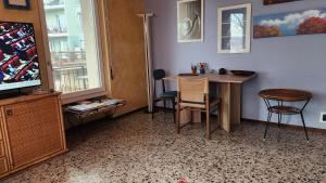 une pièce avec une table, des chaises et une télévision dans l'établissement Lago a colazione pranzo e cena, à Dormelletto