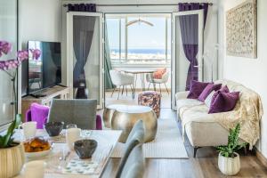 a living room with a couch and a table with purple pillows at Tropical Ocean View - Détente & Vue mer - Wiskeys in Saint-Denis