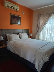 Postel nebo postele na pokoji v ubytování Rustenburg Palm Lodge