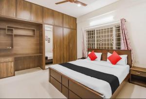 a bedroom with a large bed with red pillows at SLN Suites, Near Baptist Hospital, Hebbala in Bengaluru