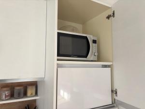 a microwave sitting on top of a shelf in a kitchen at Cozy Corner Treviso Station #4 in Treviso