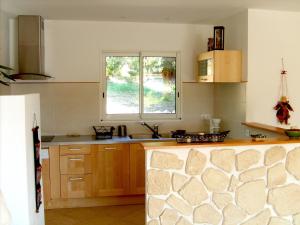 una cucina con un lavandino e una finestra di Villa avec piscine hors sol à 10mn de la plage a Lecci
