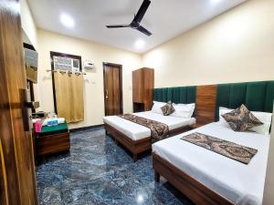 a hotel room with two beds and a ceiling fan at Hotel Anjana Cottage - Stay 5 min Away From Golden Temple in Amritsar