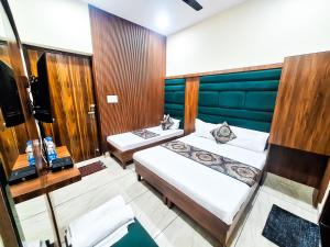 a hotel room with two beds and a television at Hotel Anjana Cottage - Stay 5 min Away From Golden Temple in Amritsar