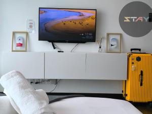 a living room with a tv on a white cabinet at Almas Warm N Comfy 2Pax Puteri Harbour BySTAY in Nusajaya