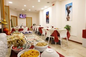 a dining room with tables and chairs with food at Hotel Palace Masoanri's in Reggio di Calabria
