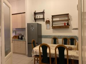 eine Küche mit einem Tisch und einem Kühlschrank in der Unterkunft Wagner Apartman in Szeged