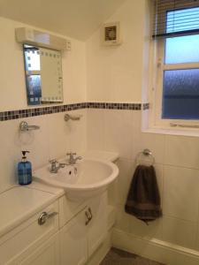 a white bathroom with a sink and a window at Rebels Hide -Self check in rooms in Penrith +32 photos