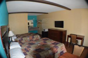 a bedroom with a bed and a desk and a television at Sun Down Lodge in Locust Grove