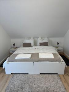 a white bed in a bedroom with white walls at Modern 2 bedroom apartment with balcony in Bad Bocklet